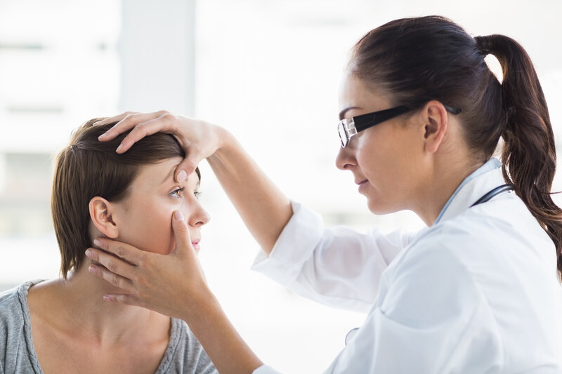 Doctor checking woman eye at clinic The Benefits of Seeing an Eye Doctor for Red Eyes